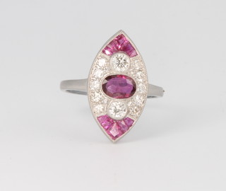 A platinum, diamond and ruby marquise shape ring set with an oval cut ruby and flanked by princess cut rubies, size M 1/2 