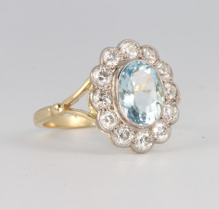 An 18ct yellow gold oval aquamarine and diamond cluster ring, the centre stone approx. 1.5ct, surrounded by brilliant cut diamonds approx, 0.85ct, size O 
