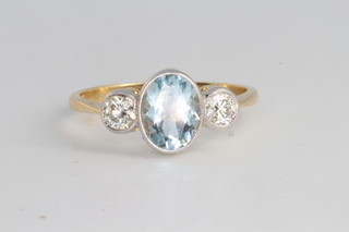 An 18ct yellow gold oval aquamarine and diamond ring, the centre stone approx. 1.25ct, flanked by 2 diamonds each 0.2ct, size P 1/2