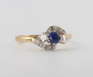 An 18ct yellow gold 3 stone sapphire and diamond crossover ring, size N 