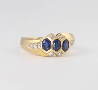 An 18ct yellow gold 3 stone sapphire and diamond ring 4.6 grams, size L 