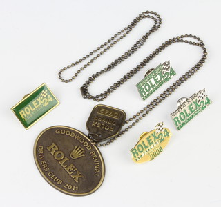 A Rolex enamelled lapel badge, 3 others and a driver's entrance medallion 