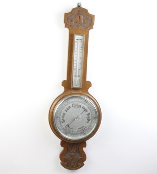 A 1930's aneroid barometer with 20cm silvered dial contained in a carved oak case (top to thermometer case is missing) 