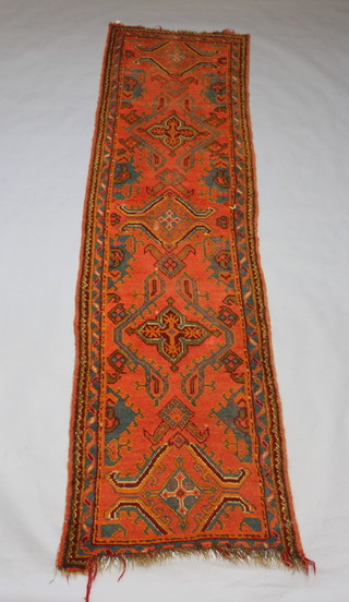 A green and orange ground Turkey runner with 5 stylised medallions to the centre 354cm x 92cm 
