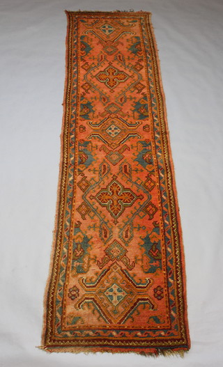 An orange ground Afghan runner with 5 stylised medallions to the centre 359cm x 94cm 