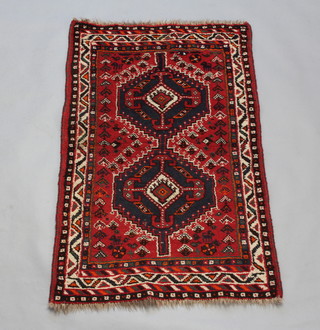 A red and blue ground Afghan rug with 2 central medallions within a multi row border 124cm x 80cm 