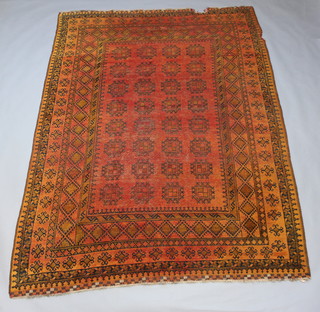 A black and orange ground Afghan carpet with 32 stylised medallions to the centre within a multi row border 305cm x 220cm 