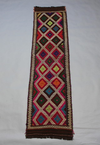 A multi-coloured Suzni Kilim rug with diamonds to the centre 265cm x 65cm 