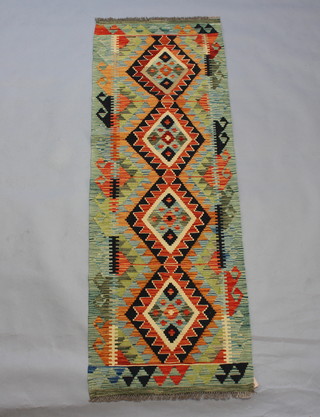 A Kilim green, brown and yellow ground runner with 4 stylised diamonds to the centre 
