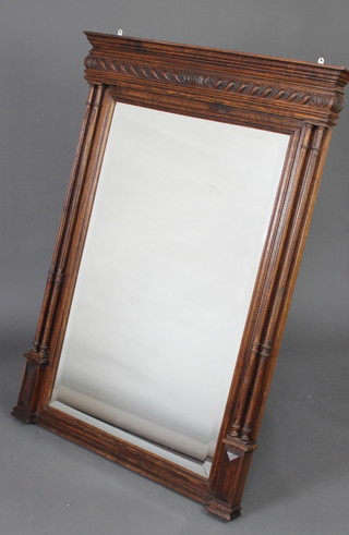 A 19th Century French rectangular bevelled plate wall mirror contained in a carved oak frame with moulded cornice, with turned and fluted columns to the sides 130cm h x 94cm w 