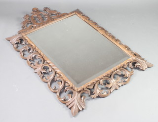 A Victorian rectangular bevelled plate mirror contained in a carved oak Rococo style frame with lion surmount 136cm x 90cm 