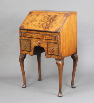 A 1930's Queen Anne style figured walnut and crossbanded bureau, the fall front revealing a well fitted interior above 1 long and 2 short drawers, raised on cabriole supports 97cm h x 61cm w x 40cm d 