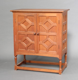 An Art Nouveau teak cabinet of panelled construction, fitted 3 pigeon holes above 3 short drawers flanked by 6 short drawers, raised on turned and block supports with box framed stretcher 118cm h x 93cm w x 53cm d 