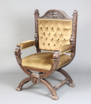A Victorian, Italian style carved oak open arm chair raised on X framed supports, the seat and back upholstered in brown buttoned material 