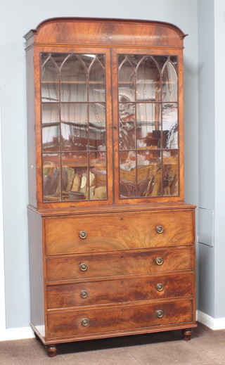A Georgian mahogany secretaire bookcase, the upper section with arched cornice fitted shelves enclosed by astragal glazed panelled doors, the base fitted a secretaire drawer revealing a well fitted interior above 3 long graduated drawers on bun supports 252cm h x 123cm w x 56cm d 
