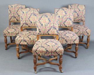 A set of 5 Edwardian oak framed dining chairs with upholstered seats and backs, raised on cup and cover supports with X framed stretchers 