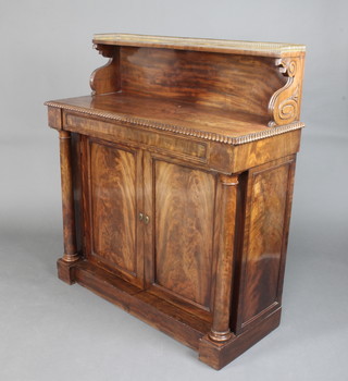 A Regency mahogany chiffonier, the raised back with brass 3/4 gallery, the base with gadrooning, fitted a secret drawer above a pair of cupboards enclosed by panelled doors and with turned columns to the sides 119cm h x 107cm w x 44cm d  