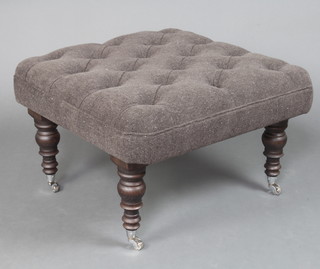 A Victorian style footstool upholstered in black felt material, raised on turned ebonised supports with chrome caps and casters 46cm h x 70cm w x 68cm d 