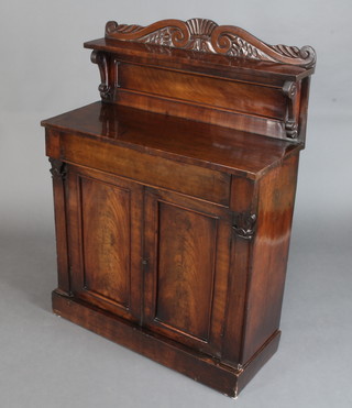 A 19th Century mahogany chiffonier with raised carved back fitted a drawer above a cupboard enclosed by panelled doors, raised on a platform base 122cm h x 88cm w x 37cm