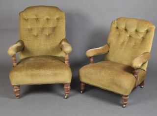 A pair of Howard style open arm chairs upholstered in green buttoned material raised on turned supports with brass caps and casters  