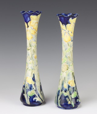 A near pair of William Moorcroft Macintyre Florian Ware waisted vases decorated with yellow irises on a blue ground, having a printed signature 25cm and 25.5cm 