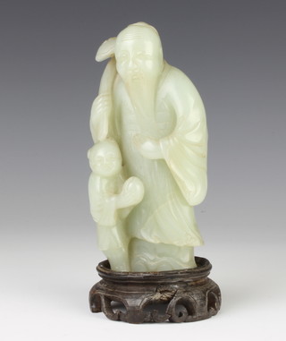 A jade figure of Shou Lao, c1900, the figure in grey-green stone standing holding a ru-i sceptre above a boy with a peach, 15cm 
