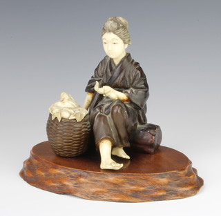 A Japanese Meiji period bronze and ivory mounted figure of a girl sitting on a trunk with a basket before her containing carved ivory fruit, signed, 14cm, on a wood stand  