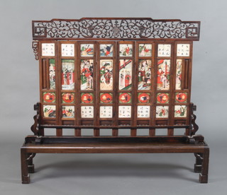 A mid 19th Century painted marble screen, formed of numerous white tablets with brightly coloured dignitaries and ladies between women and children, inscriptions and precious objects, the reverse with rocky landscapes and flowers, all mounted in hardwood framing surmounted by a carved and pierced crest of Shou and Chilong and on a long stand, 66cm h  x 109 cm w