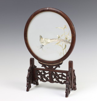 A Chinese silk work circular embroidery of an exotic bird contained in a circular hardwood frame and stand 34cm 