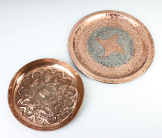 A circular Newlyn style planished copper dish decorated fish 28cm diam. together with a circular embossed copper bowl with bird and floral decoration 22cm diam. 