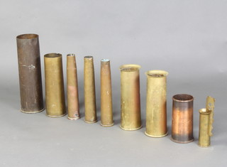 A pair of WWI  brass Trench Art vases formed from 18lb shell cases marked 1916, 1 other dated 1915, a large brass shell case marked M14 1963, 3 40mm shell cases dated 1943, 1950 and 1955, a brass Trench Art vase dated 1942 engraved a cottage and a Trench Art vase formed from an 18lb shell case marked 1917 and a button stick   
