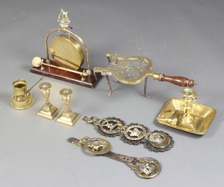 A 19th Century brass chamber stick, 2 brass squat candlesticks, tea gong, martingale hung 3 horse brasses, trivet, and a small brass jug 