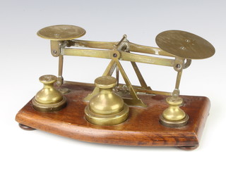 T J and J Smith London, a pair of Victorian brass letter scales raised on a wooden stand complete with 6 weights 