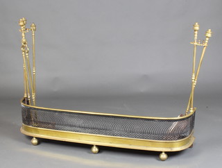 A Victorian brass and pierced steel fender, the sides fitted removable associated companion stands with shovel, poker and tongs, raised on bun feet 79cm h x 112cm h x 26m d 