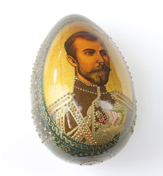 A Russian painted and lacquered egg decorated a portrait of Tsar Nicholas II 9cm x 5cm 