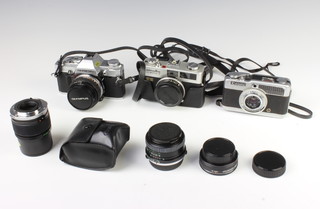 A Minolta Hi.Matic F camera, an Olympus OM30 camera together with a Canon Demi camera,  a Mirage lens 28M 1:2.8MC micro lens and an Olympus OM-System Zuiko auto-T 135mm 1:33.5410050 lens 