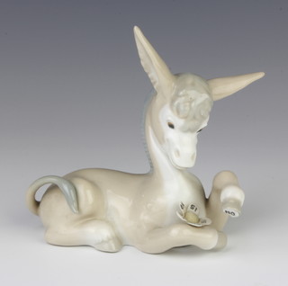 A Lladro figure of a reclining donkey with love me, love me not daisy in Spanish 11cm 