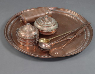 An Eastern circular copper charger 71cm, an engraved jar and cover and 1 other, brass ladle, 2 copper ladles, a cream skimmer and a foot warmer