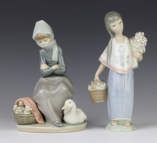 A Lladro figure of a young girl holding a basket of fruit 22cm, a ditto of a seated goose girl 20cm 
