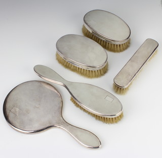 An Art Deco style silver engine turned dressing table set comprising hand mirror, a pair of gentleman's hair brushes, a hair brush and clothes brush 