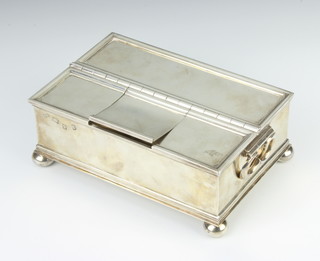 A rectangular silver treasury ink stand with 1 long compartment and 3 short lidded compartments, raised on bun feet, London 1951, 18cm, 1095 grams