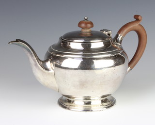A silver bulbous bodied teapot with fruitwood handles London 1933, gross 553 grams, 