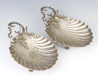 A pair of 19th Century French silver scallop shaped dishes with scrolling floral handles, 24cm 608 grams