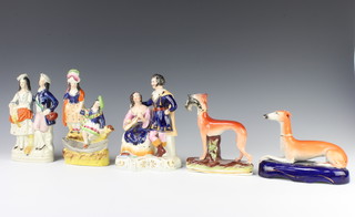 A Staffordshire pen holder in the form of a reclining greyhound 17cm (chipped), a Staffordshire hound with a rabbit in its mouth 15cm (with paint loss), a group of two Scottish ladies 20cm, another of a lady and gentleman 18cm and a group of Queen Victoria and Prince Albert 19cm (chipped)