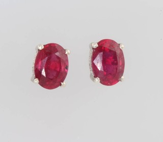 A pair of oval treated ruby ear studs