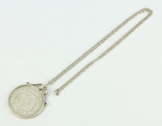 A silver dollar contained in a silver mount hung on a silver chain 