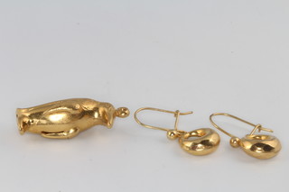 A 9ct yellow gold penguin charm and a pair of hoop earrings, 3 grams 