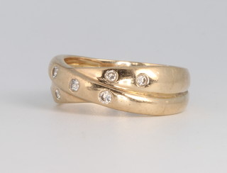 A 9ct yellow gold diamond set crossover ring 5.4 grams, size O 1/2