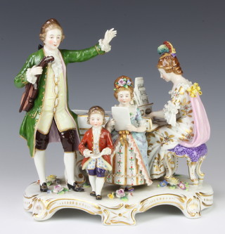 A Salopian conversation group of a lady playing a piano forte with a gentleman and 2 children raised on a Rococo base with applied flowers 25cm 