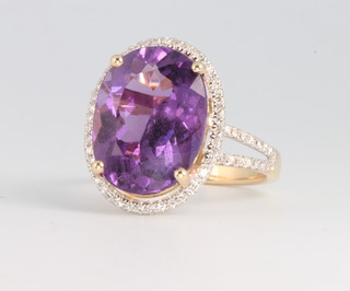 A 14ct yellow gold oval cut amethyst and diamond cluster ring, the centre stone approx. 6.92ct surrounded by brilliant cut diamonds approx. 0.3ct, size M 